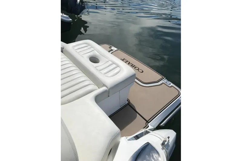 Slide: The Image of 2016 Cobalt R5 boat with white seating and branded swim platform on water. - 2
