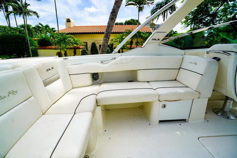 Slide: The Image of 2010 Sea Ray 270 SLX boat interior with white leather seating and tropical background. - 12