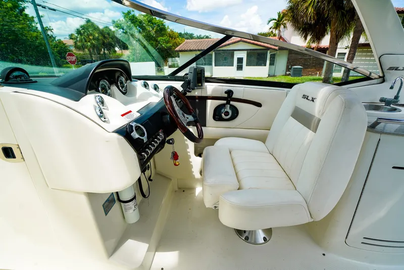 Slide: The Image of Interior of 2010 Sea Ray 270 SLX boat with white seating and control panel. - 16