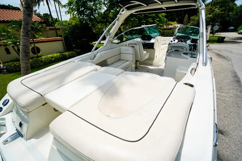 Slide: The Image of 2010 Sea Ray 270 SLX boat with spacious seating and sleek design, parked outdoors. - 8