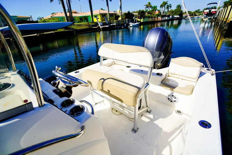 Slide: The Image of 2016 Robalo 206 Cayman boat with beige seating, docked in a sunny canal. - 8
