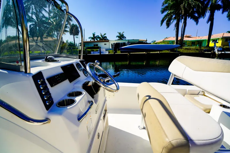 Slide: The Image of 2016 Robalo 206 Cayman boat interior with steering console, beige seating, and waterfront view. - 9