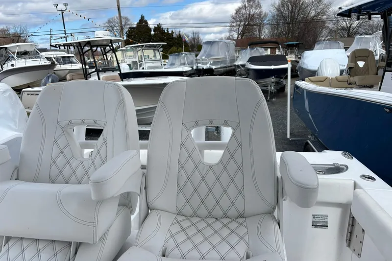 Slide: The Image of 2021 Sportsman Open 252 Center Console boat seats, surrounded by various boats in a marina. - 10
