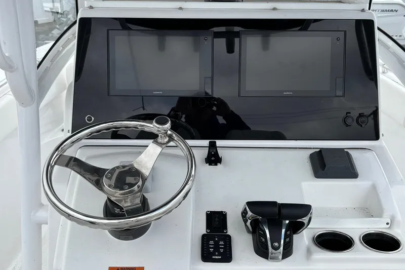 Slide: The Image of 2021 Sportsman Open 252 Center Console helm with dual Garmin displays and steering wheel. - 14