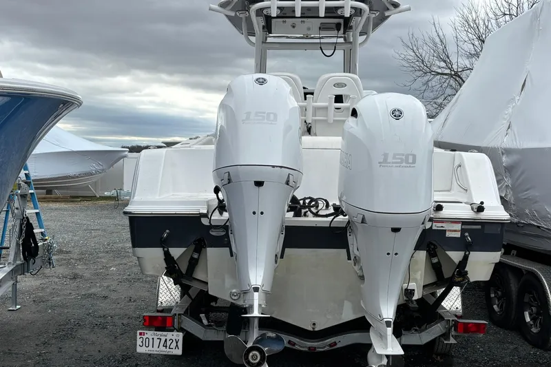 Slide: The Image of 2021 Sportsman Open 252 Center Console boat with twin Yamaha 150 engines, parked outdoors. - 2