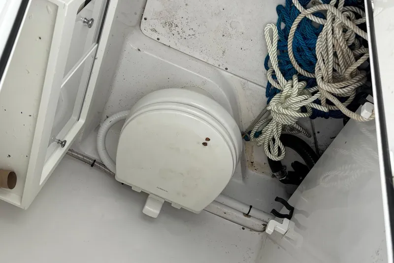 Slide: The Image of Storage compartment in a 2021 Sportsman Open 252 Center Console boat with ropes and equipment. - 20