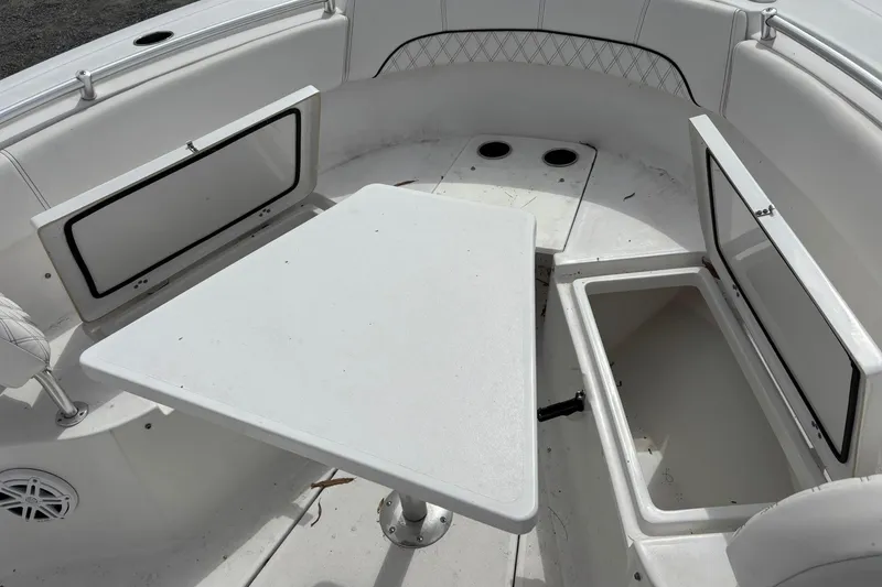 Slide: The Image of 2021 Sportsman Open 252 Center Console boat interior with storage compartments and table. - 25