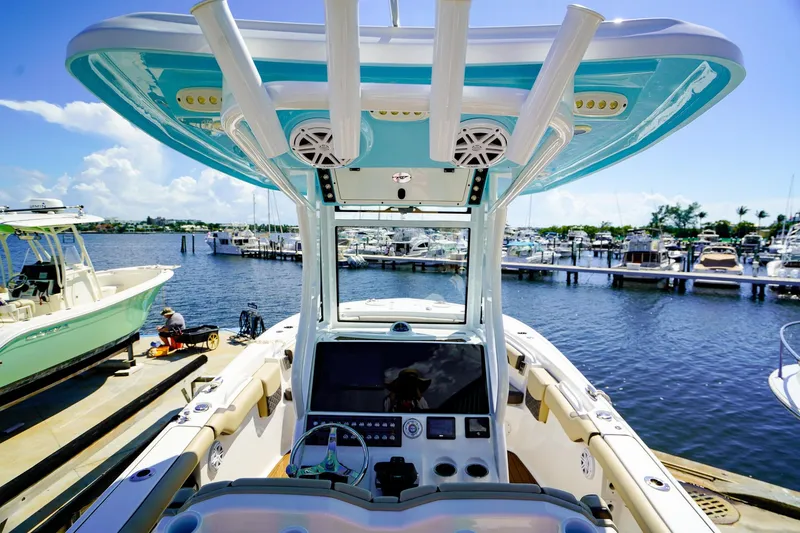 Slide: The Image of 2021 Tidewater 256 LXF boat docked at marina, featuring modern helm and vibrant blue accents. - 10