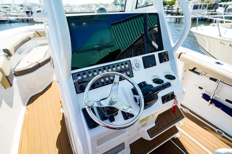 Slide: The Image of 2021 Tidewater 256 LXF boat helm with modern controls and steering wheel. - 12