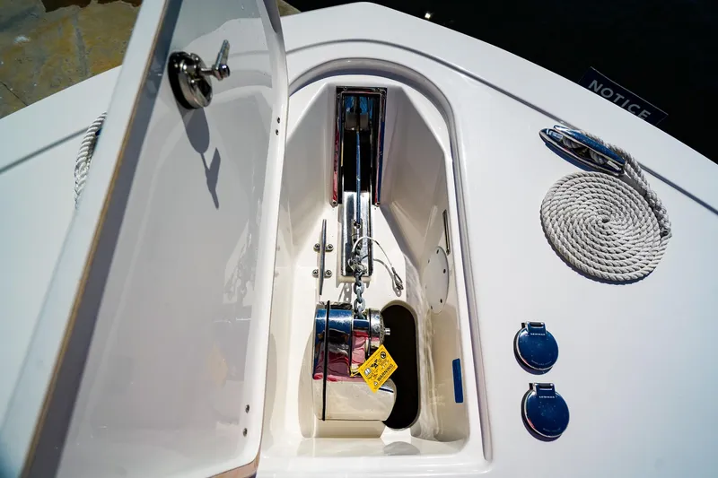Slide: The Image of 2021 Tidewater 256 LXF boat anchor compartment with coiled rope and chrome fittings. - 23