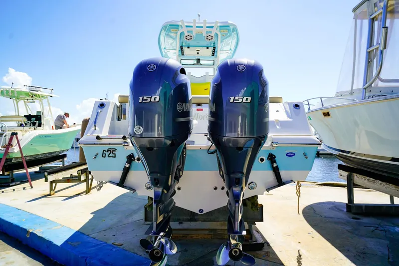 Slide: The Image of 2021 Tidewater 256 LXF boat with dual Yamaha 150 engines at dockside. - 26