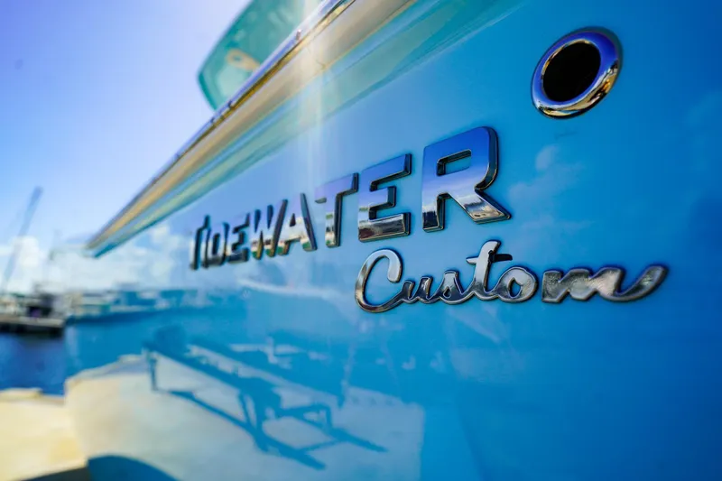 Slide: The Image of 2021 Tidewater 256 LXF boat with custom blue finish, docked under clear sky. - 28