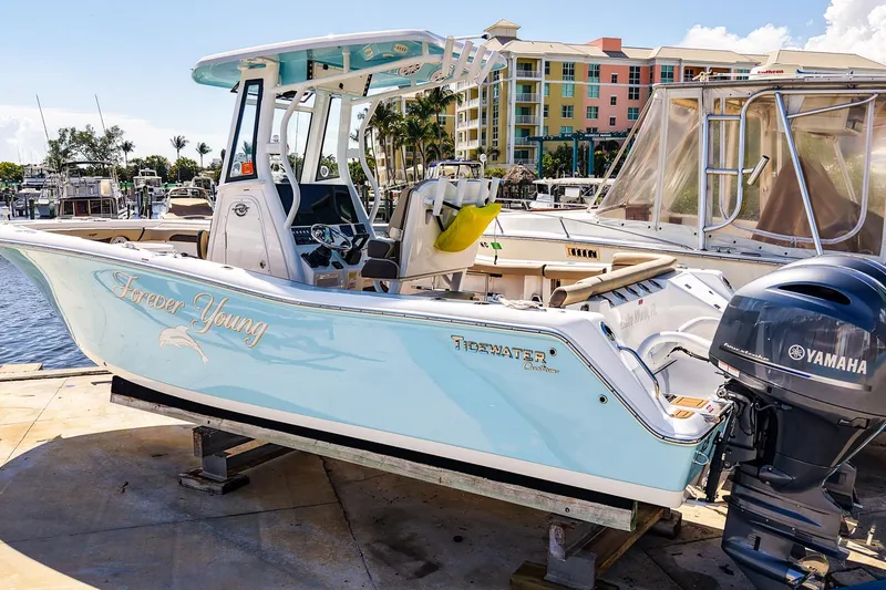 Slide: The Image of 2021 Tidewater 256 LXF boat docked, featuring Yamaha engine, with "Forever Young" text on the side. - 31