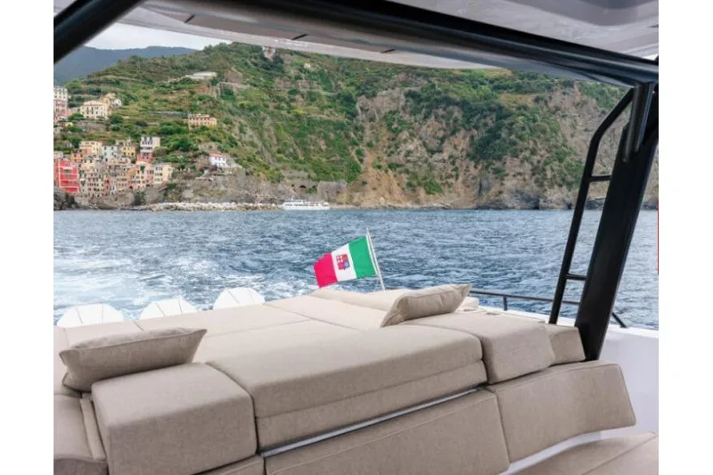 Slide: The Image of Luxurious 2027 Axopar 45 Sun-Top yacht cruising near scenic coastal cliffs. - 7