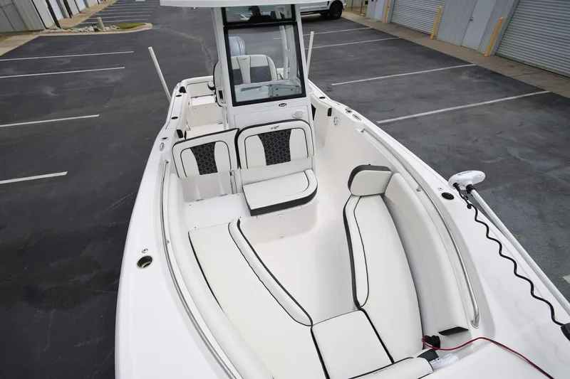 Slide: The Image of 2023 Tidewater 232 SS boat with spacious seating and modern design in a parking lot. - 18