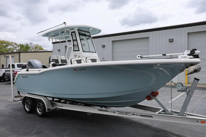 Slide: The Image of 2023 Tidewater 232 SS boat on trailer, parked outside a warehouse. - 7