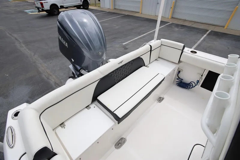 Slide: The Image of 2023 Tidewater 232 SS boat interior with Yamaha engine, featuring white seating and rod holders. - 8