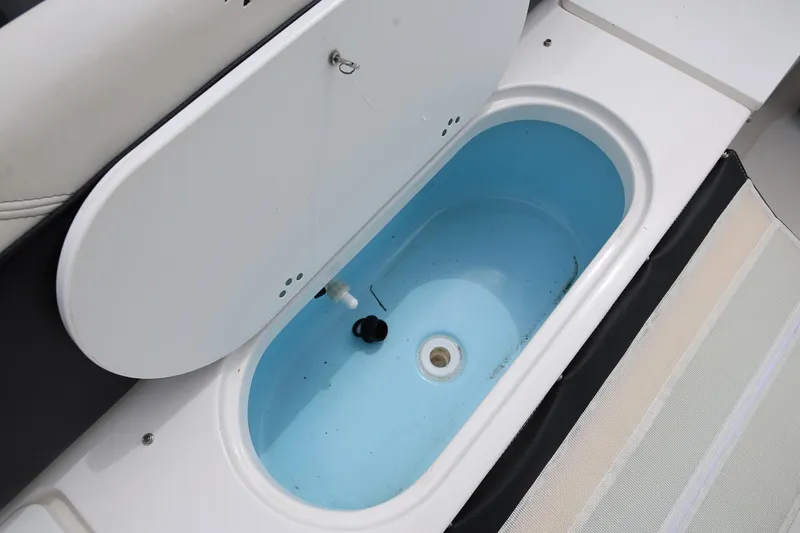 Slide: The Image of 2023 Tidewater 232 SS boat livewell with open lid, showcasing interior design. - 9