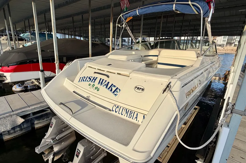 Slide: The Image of 2000 Formula 280 Bowrider boat docked, featuring "Irish Wake" name and covered seating. - 4