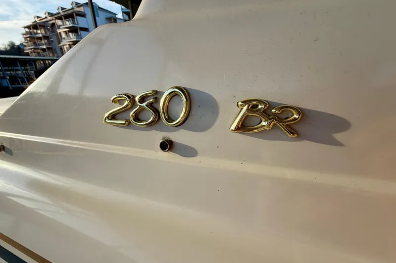 Slide: The Image of Gold '280 BR' emblem on 2000 Formula 280 Bowrider boat exterior. - 6