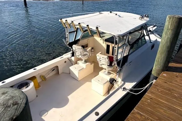 Slide: The Image of 2001 Parker 2510 Walkaround boat docked, featuring spacious deck and dual seating. - 17