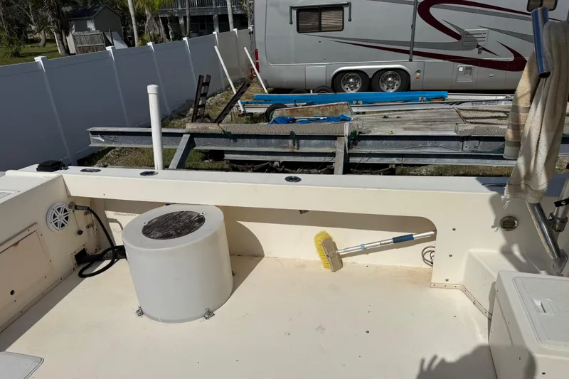 Slide: The Image of 2001 Parker 2510 Walkaround boat deck with cleaning brush and trailer in background. - 25