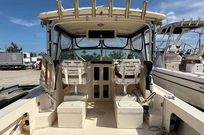 Slide: The Image of 2001 Parker 2510 Walkaround boat interior with seating and fishing rod holders. - 26