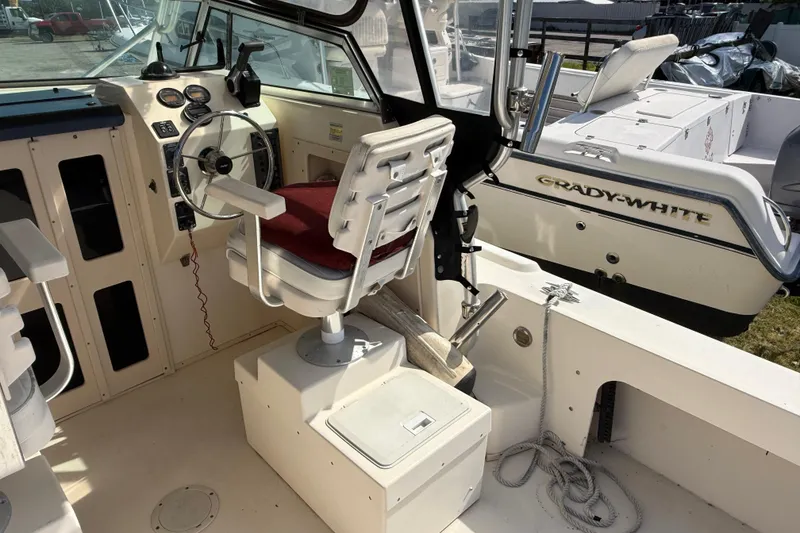 Slide: The Image of Interior of a 2001 Parker 2510 Walkaround boat with steering wheel and seating. - 27