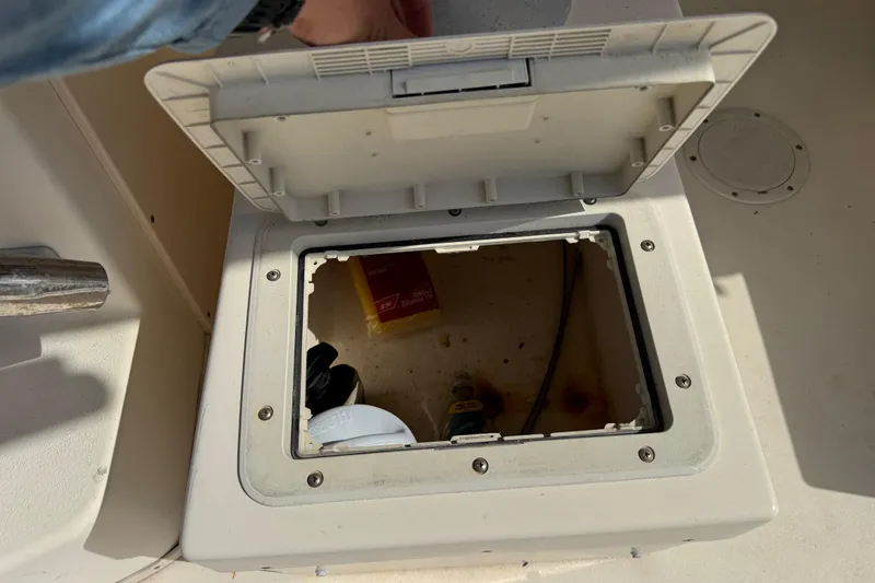 Slide: The Image of Open storage compartment on a 2001 Parker 2510 Walkaround boat, showing interior contents. - 29