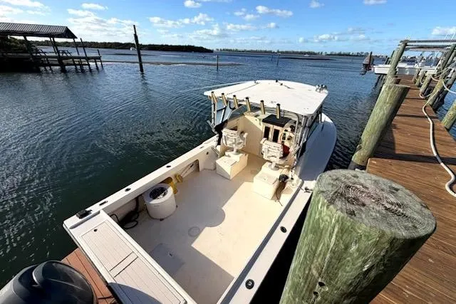Slide: The Image of 2001 Parker 2510 Walkaround boat docked on a sunny day, showcasing spacious deck. - 3
