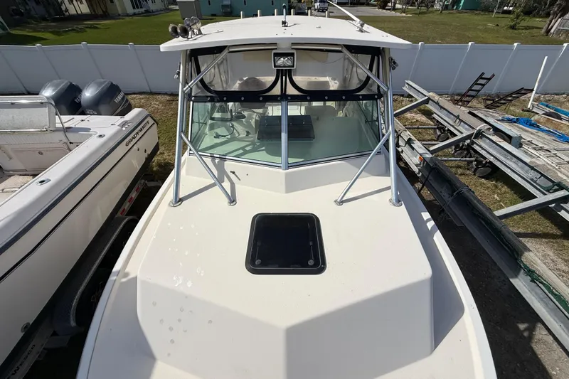 Slide: The Image of 2001 Parker 2510 Walkaround boat with windshield and hatch, docked beside another vessel. - 40