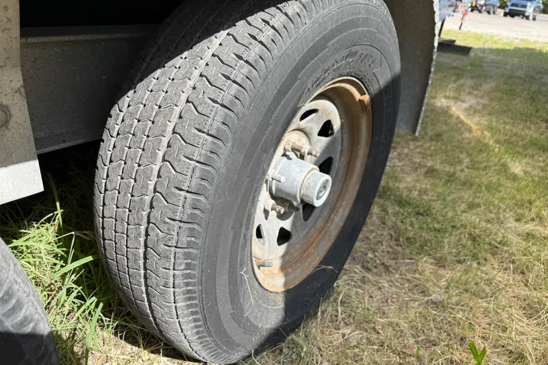 Slide: The Image of Trailer tire of a 2001 Parker 2510 Walkaround boat on grass. - 48