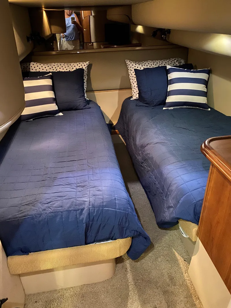 Slide: The Image of 2002 Cruisers Yachts 4270 Express cabin with twin beds and blue bedding. - 11