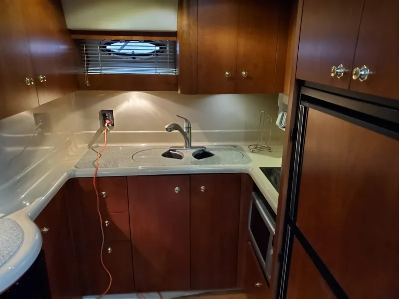 Slide: The Image of 2002 Cruisers Yachts 4270 Express kitchen with wooden cabinets and modern appliances. - 8