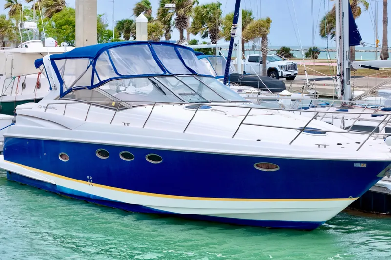 The Image of 2004 Regal Commodore 3860 yacht docked in marina, featuring sleek blue and white design. - 0