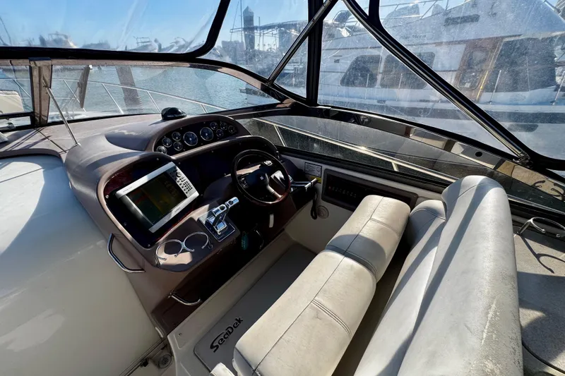Slide: The Image of 2004 Regal Commodore 3860 helm with steering wheel, navigation system, and comfortable seating. - 11