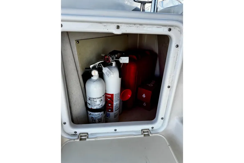 Slide: The Image of Storage compartment on 2004 Regal Commodore 3860 boat with fire extinguishers and safety equipment. - 24