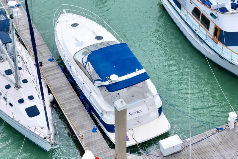 Slide: The Image of 2004 Regal Commodore 3860 yacht docked in marina with blue canopy. - 3