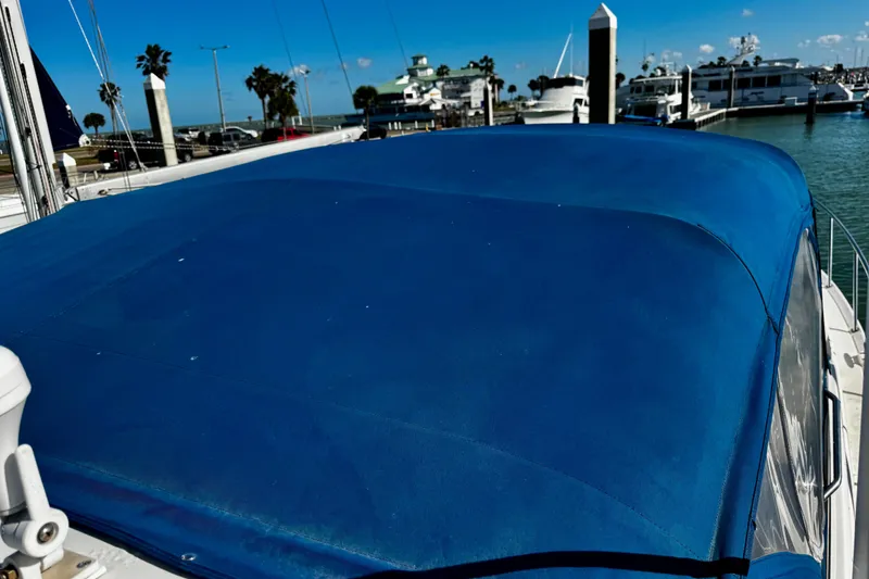 Slide: The Image of 2004 Regal Commodore 3860 with blue canvas cover docked at marina. - 32