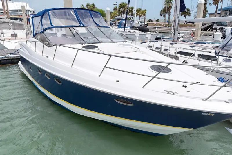 Slide: The Image of 2004 Regal Commodore 3860 yacht docked in marina, featuring sleek design and blue accents. - 4