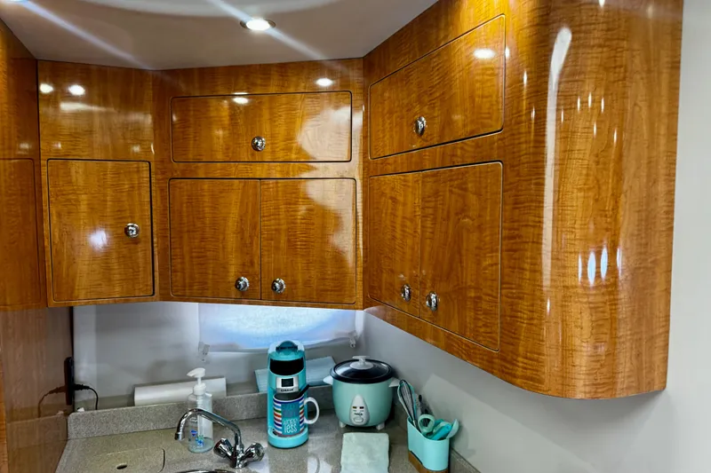 Slide: The Image of Wooden cabinets in a 2004 Regal Commodore 3860 yacht kitchen with modern fixtures. - 48
