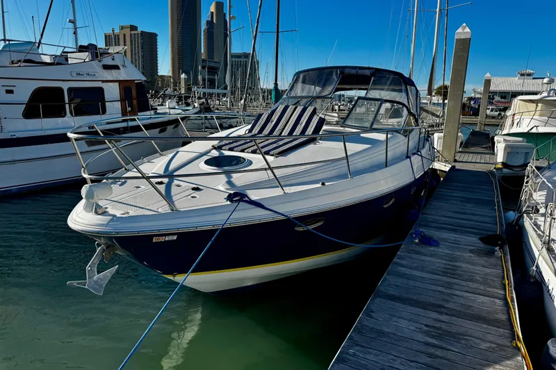 Slide: The Image of 2004 Regal Commodore 3860 yacht docked at marina with city skyline background. - 5