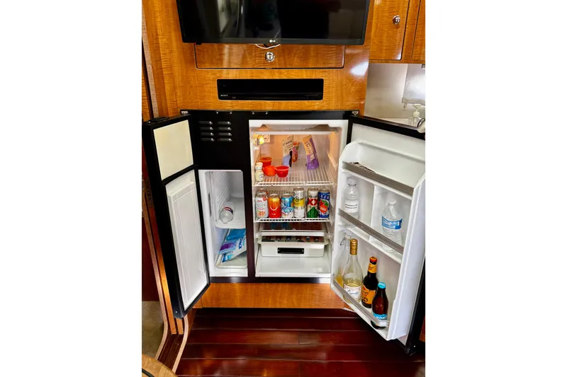 Slide: The Image of Open fridge in 2004 Regal Commodore 3860 yacht, stocked with drinks and snacks. - 51