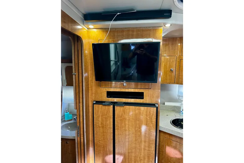 Slide: The Image of Interior of 2004 Regal Commodore 3860 yacht with TV and wooden cabinetry. - 52