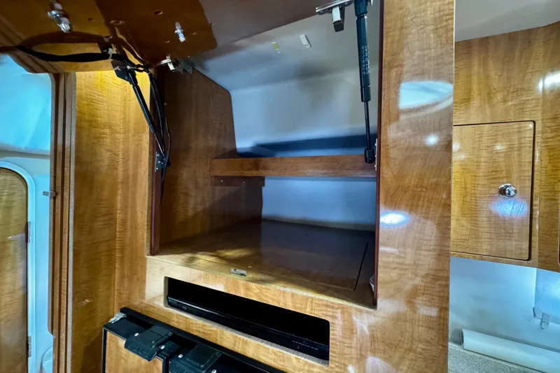 Slide: The Image of 2004 Regal Commodore 3860 interior cabinet with open wooden shelving and glossy finish. - 53