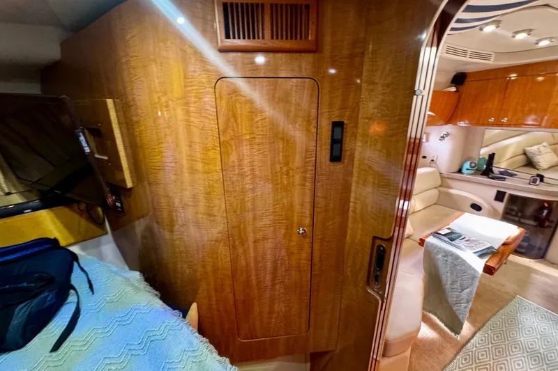 Slide: The Image of Interior of 2004 Regal Commodore 3860 yacht, featuring wood paneling and cozy seating area. - 55