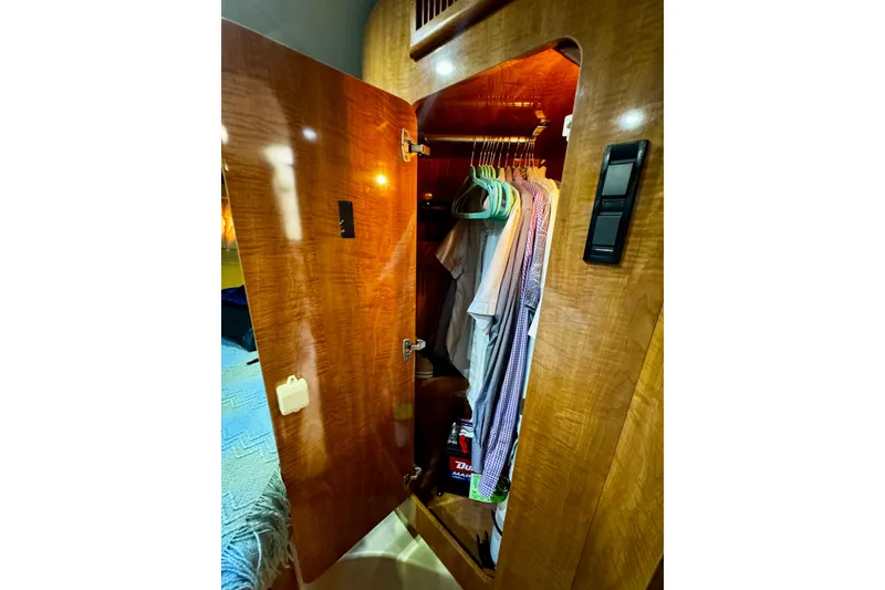 Slide: The Image of Wooden closet interior with hanging clothes in a 2004 Regal Commodore 3860 yacht. - 56