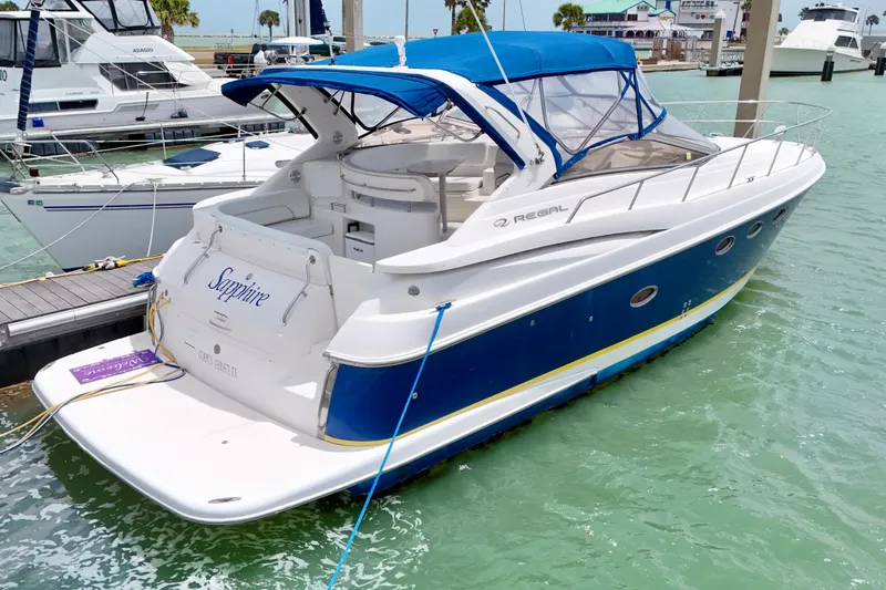 Slide: The Image of 2004 Regal Commodore 3860 yacht docked in marina with blue canopy and sleek design. - 6