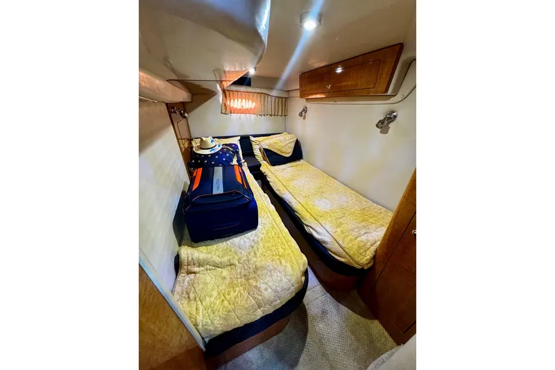 Slide: The Image of 2004 Regal Commodore 3860 cabin with twin beds, luggage, and cozy lighting. - 61