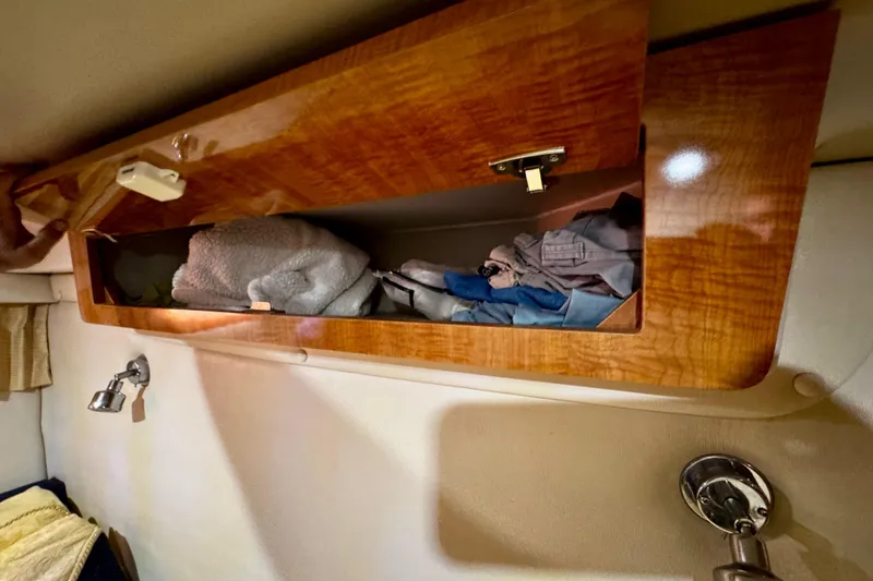 Slide: The Image of Wooden cabinet with clothes inside on a 2004 Regal Commodore 3860 boat. - 62